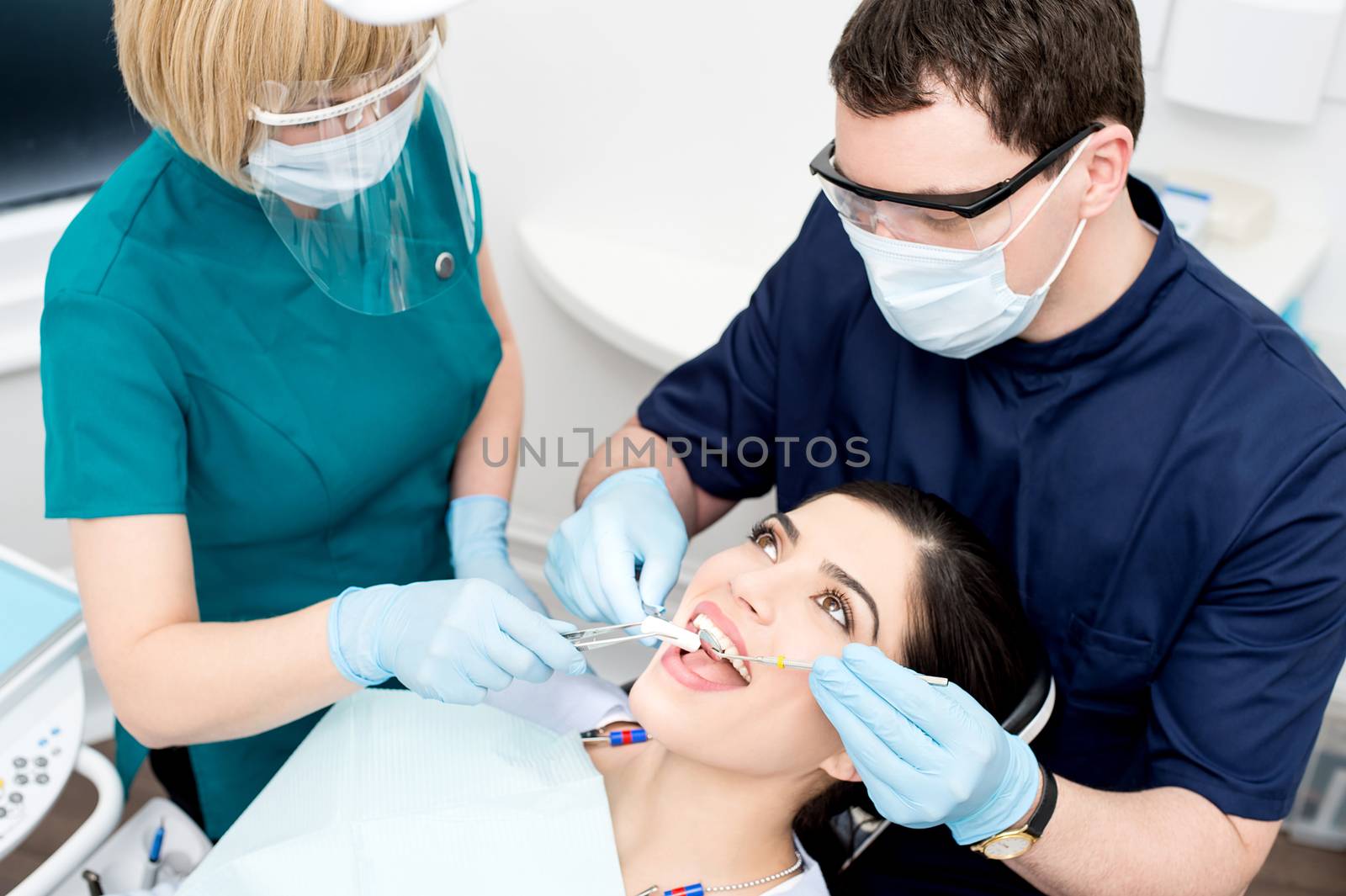 Dentist cleaning a woman teeth by stockyimages