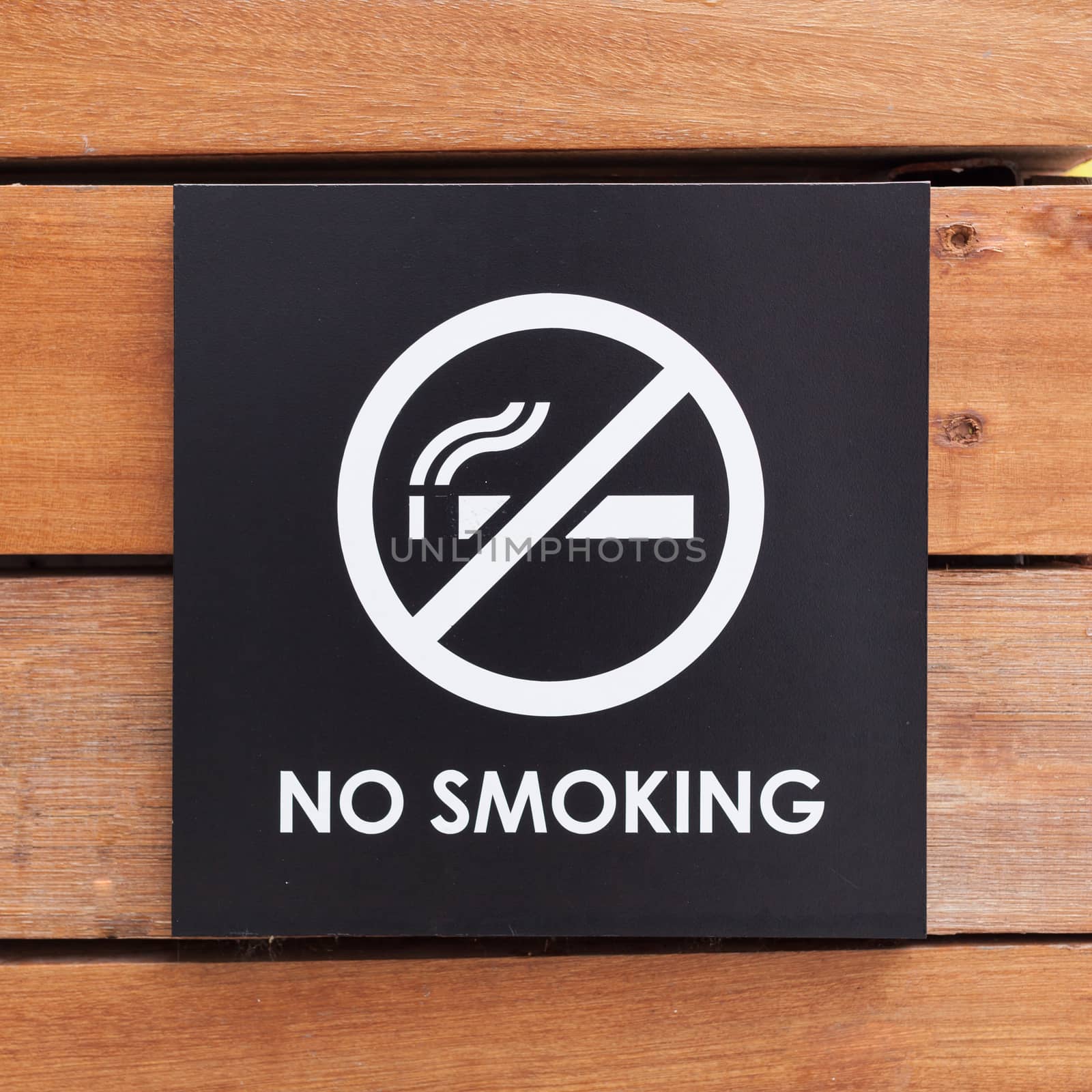 No Smoking sign on a wood wall .
