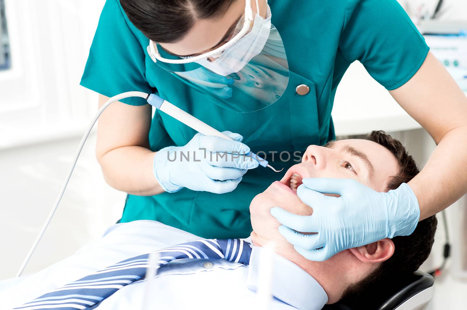 Male with open mouth during oral checkup at dentist