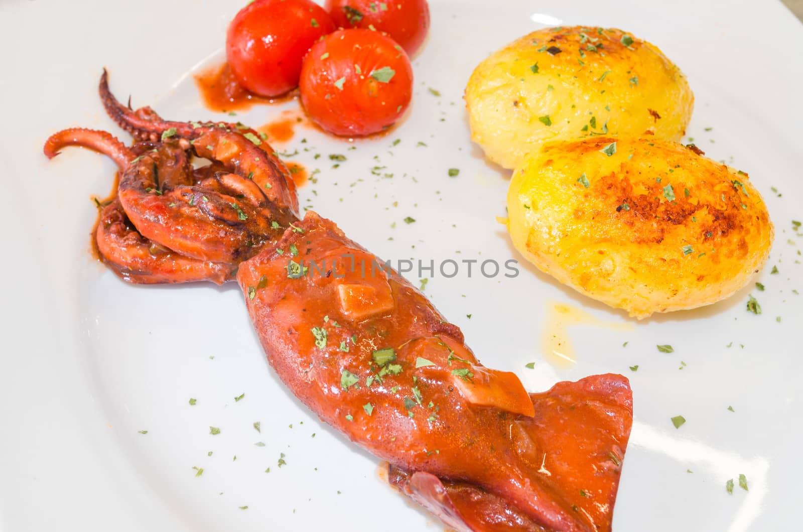 Octopus cooked with potatoes in olive oil - traditional southern dish.