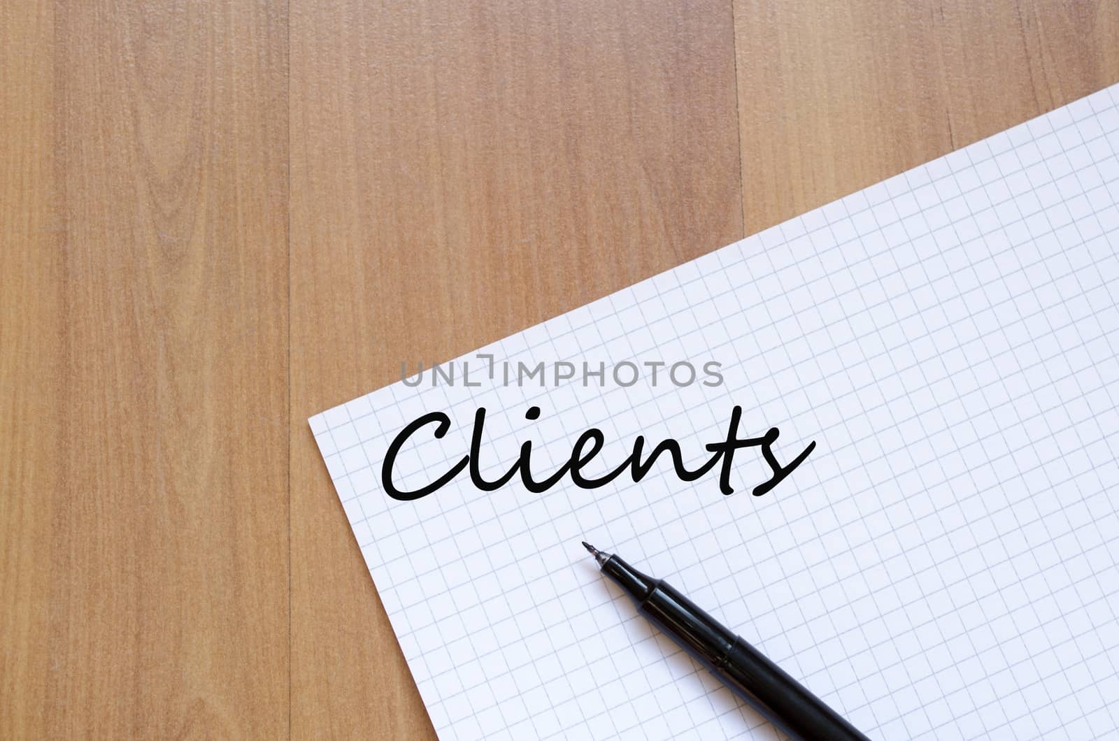 White blank notepad on office wooden table and text concept