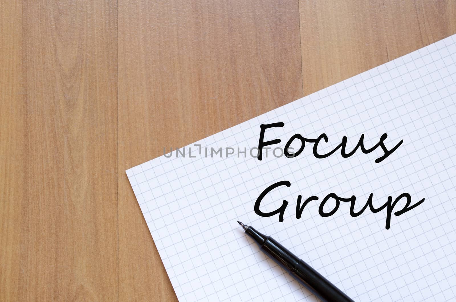 White blank notepad on office wooden table and text concept