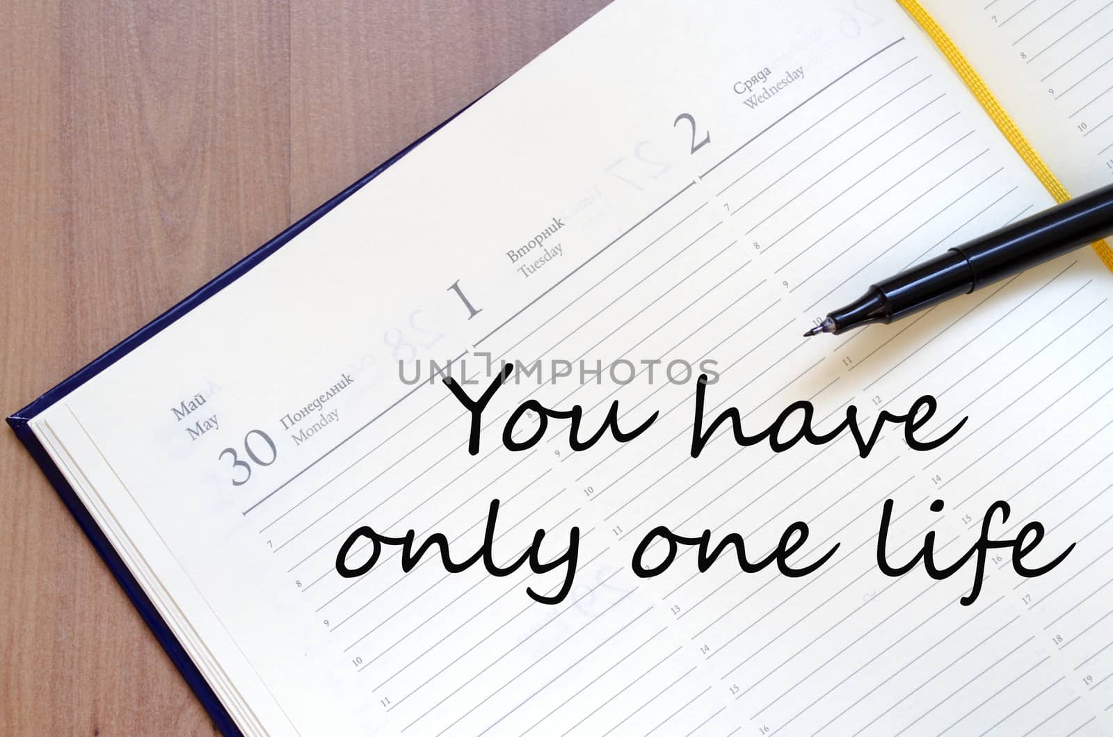 Yellow blank notepad on office wooden table and text concept