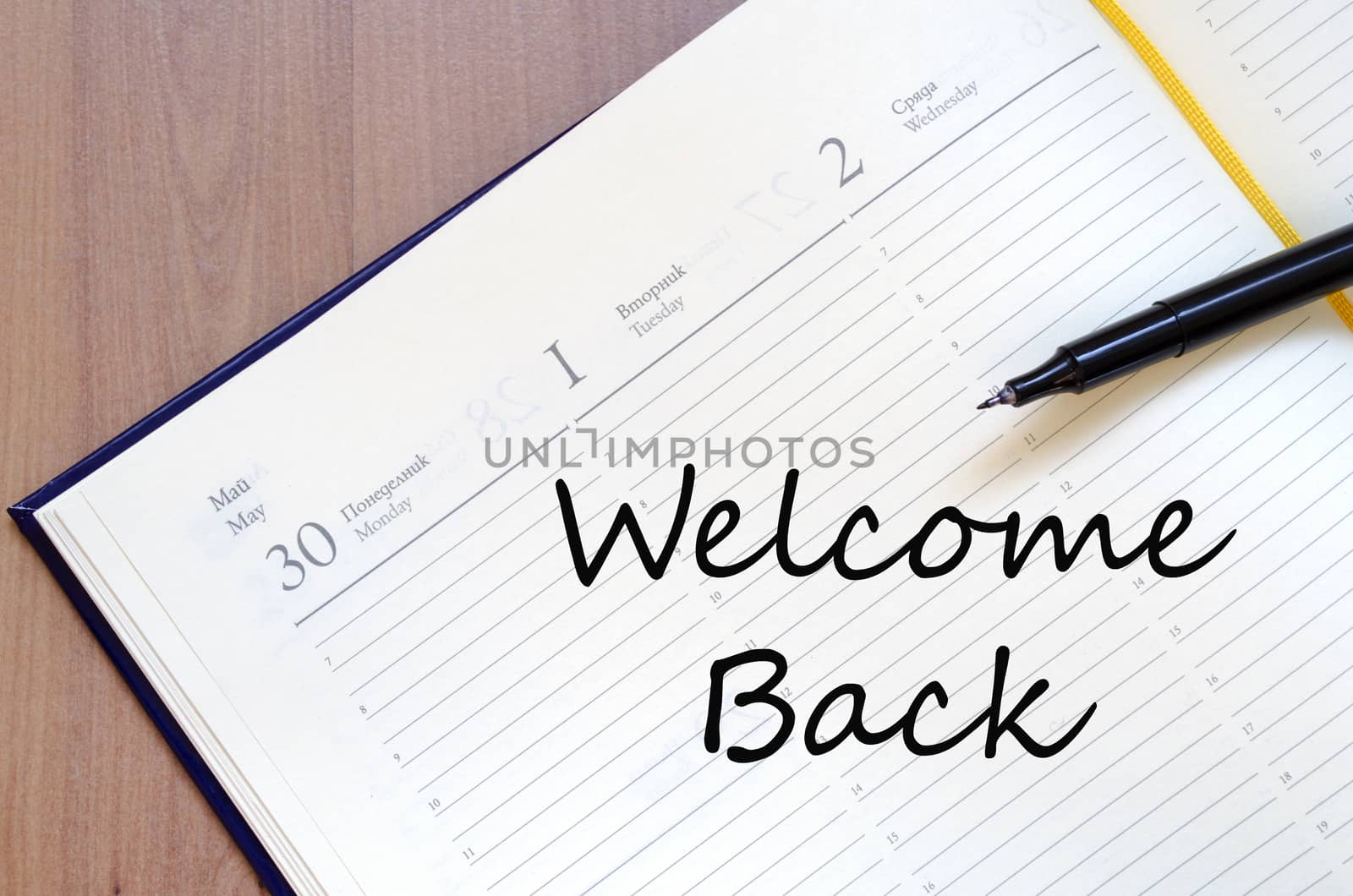 Yellow blank notepad on office wooden table and text concept