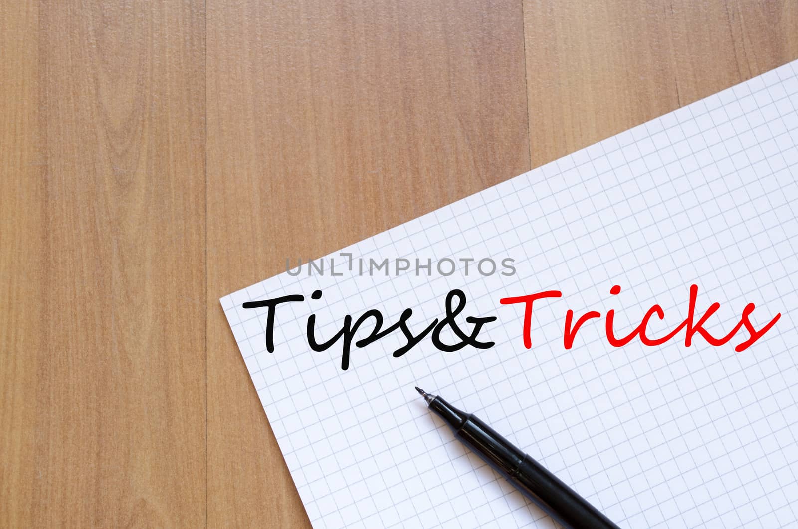White blank notepad on office wooden table and text concept