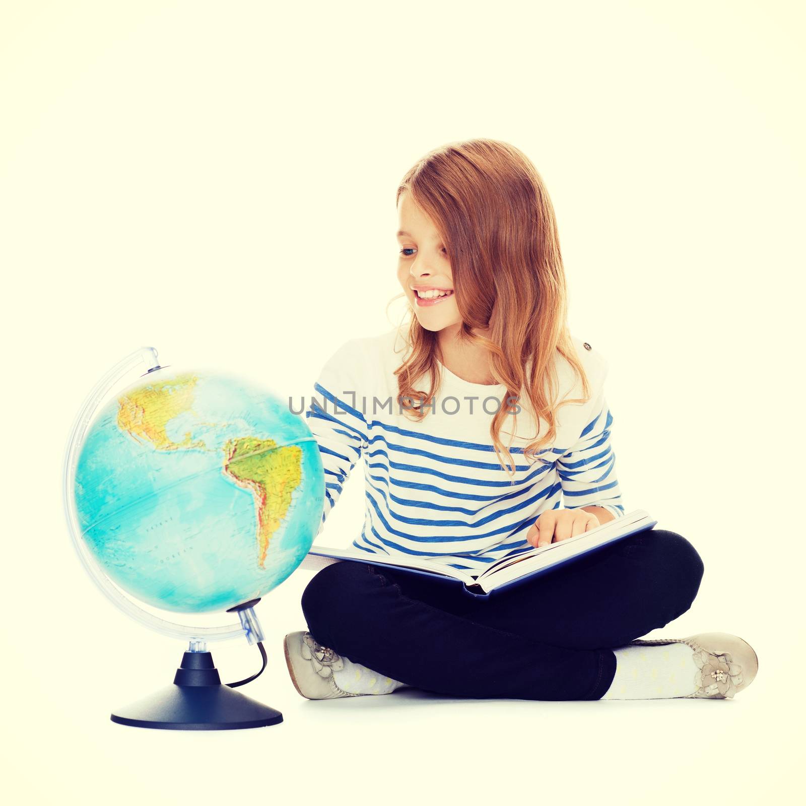 education and school concept - little student girl looking at globe and holding book