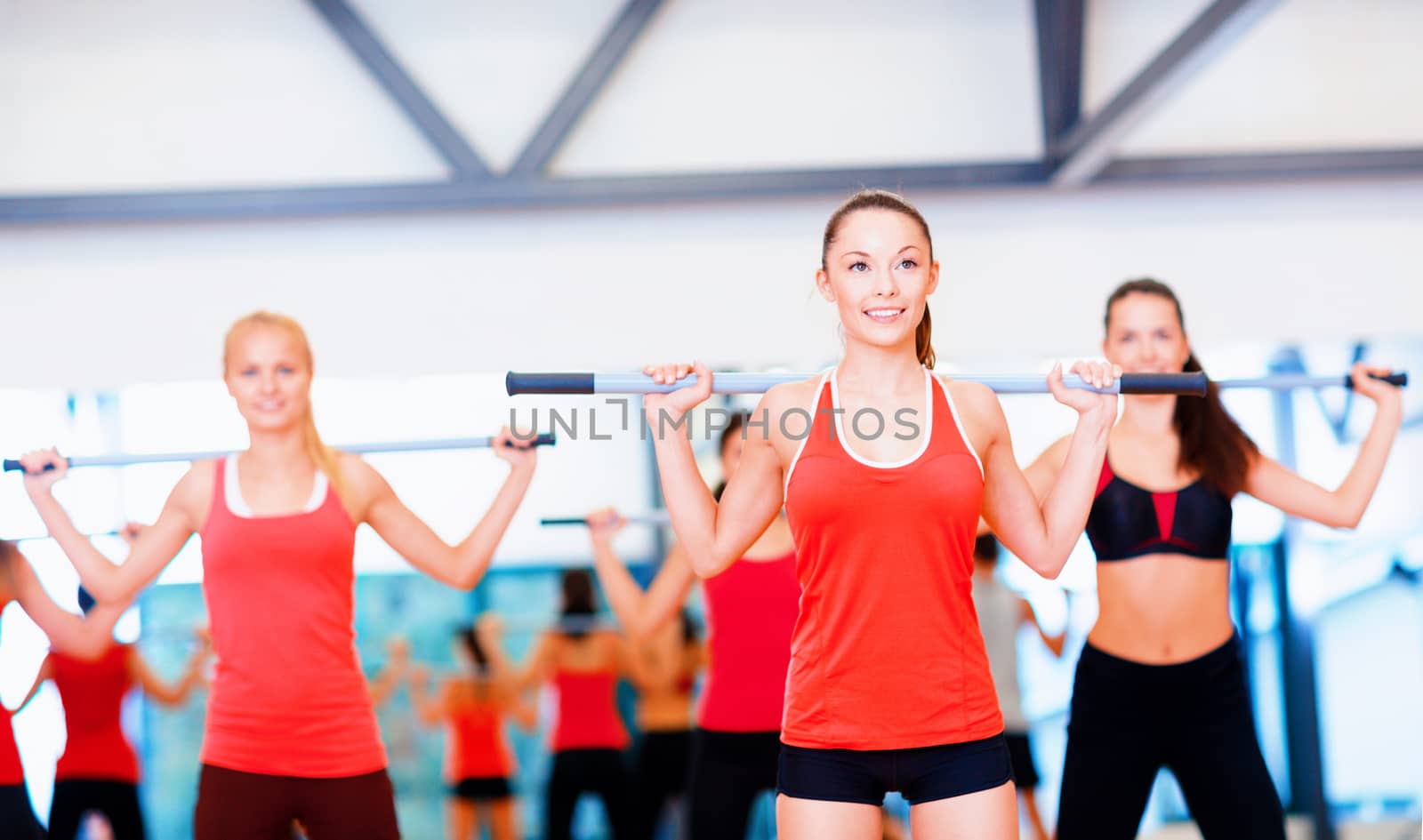 group of smiling people working out with barbells by dolgachov