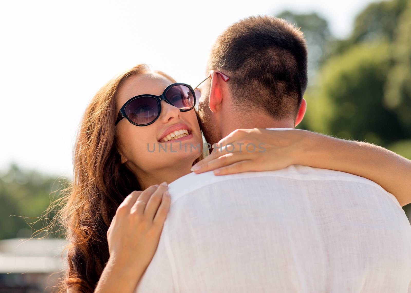 love, wedding, summer, dating and people concept - smiling couple wearing sunglasses hugging in park