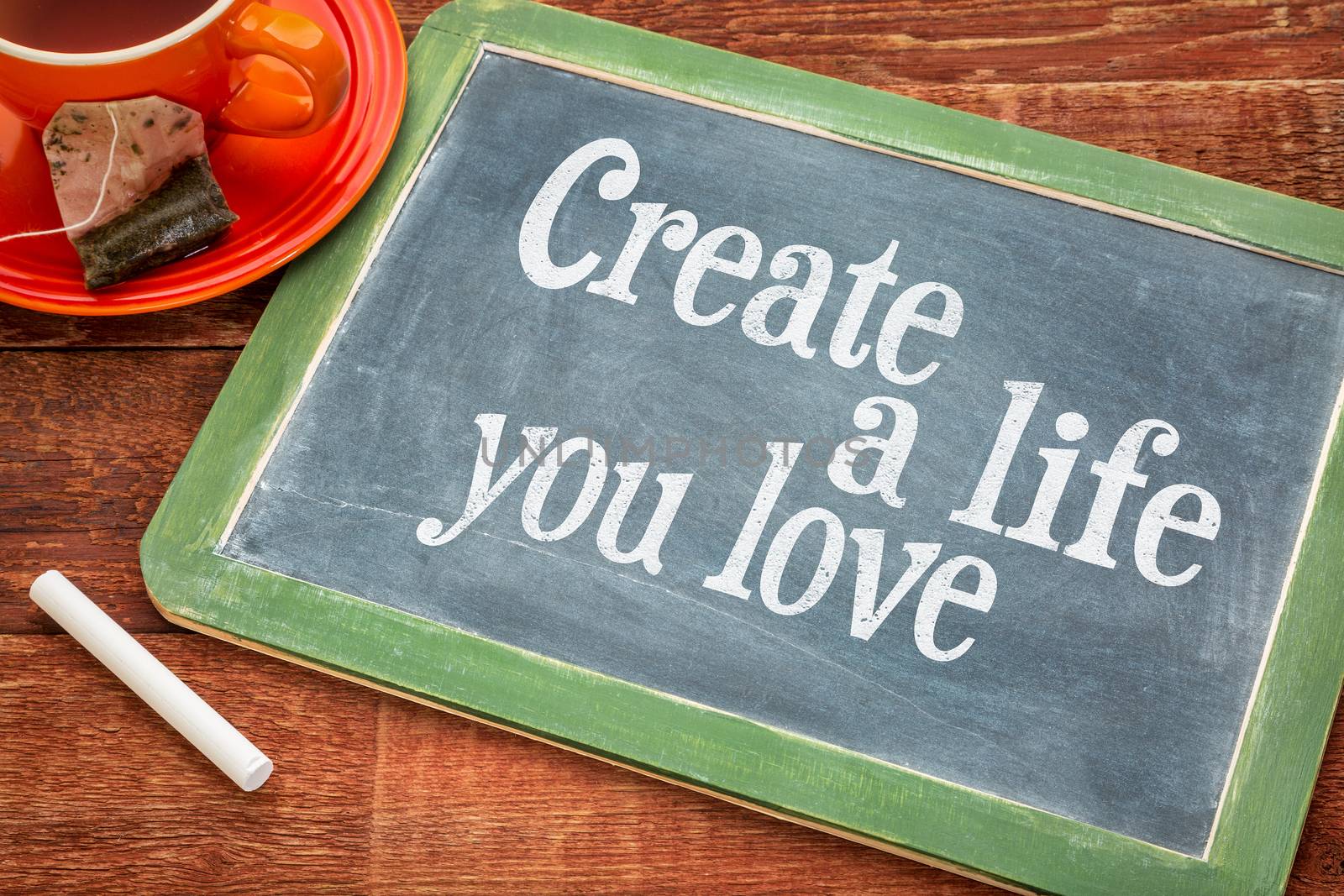 Create life you love motivational advice - text  on a slate blackboard with chalk and cup of tea