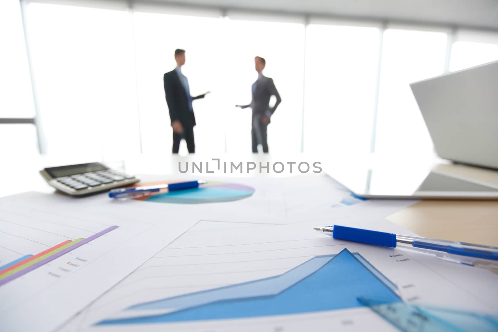 Businessmen and financial documents with diagrams at modern workplace 