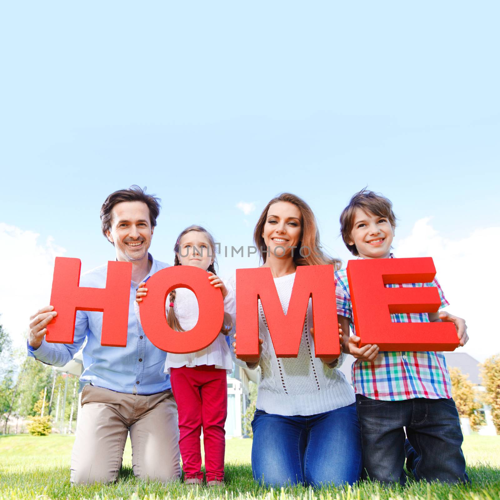 happy holding home letters in front of their house