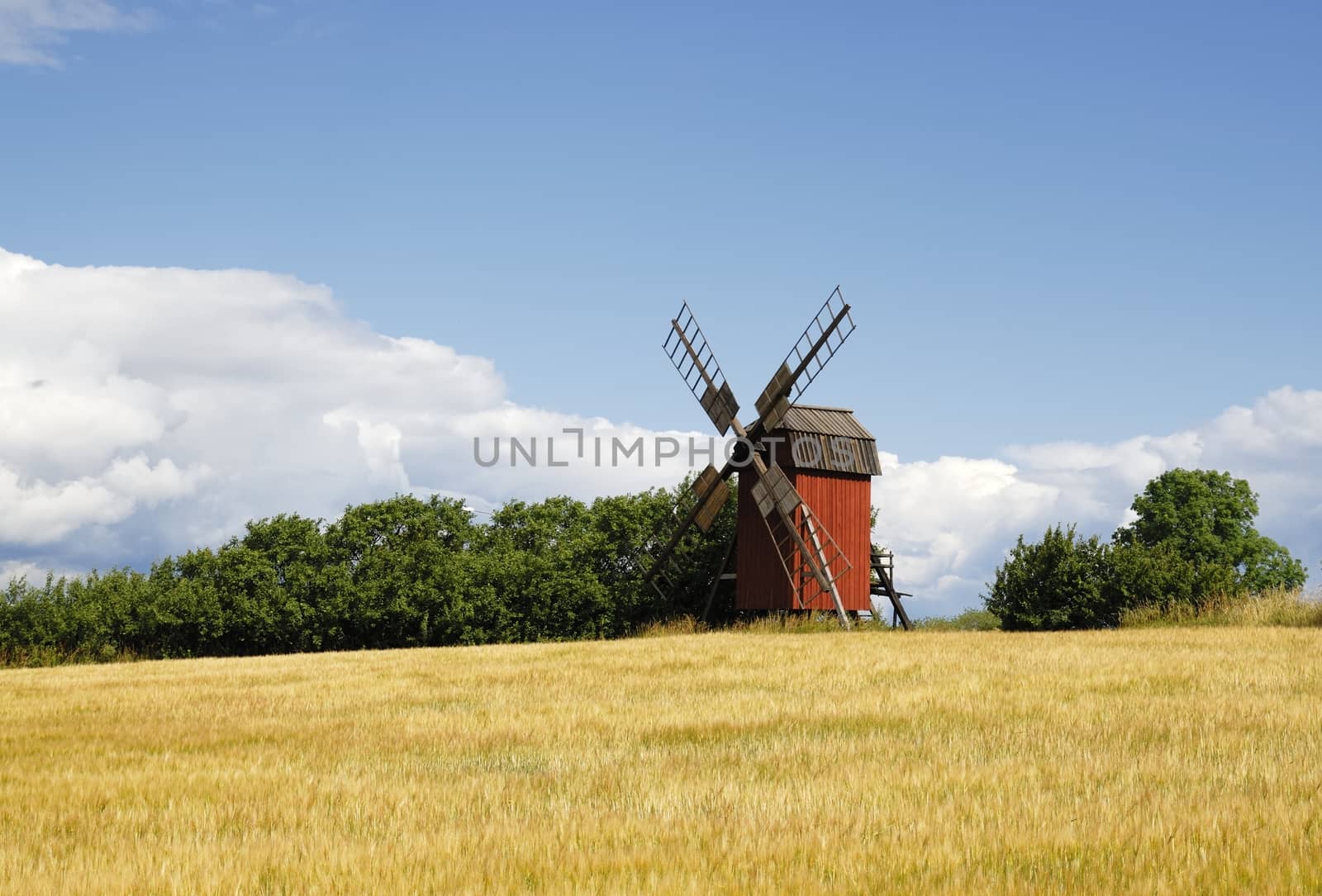 Windmill with field in a typical Swedish setting. Windmill is located in Öland, Sweden.