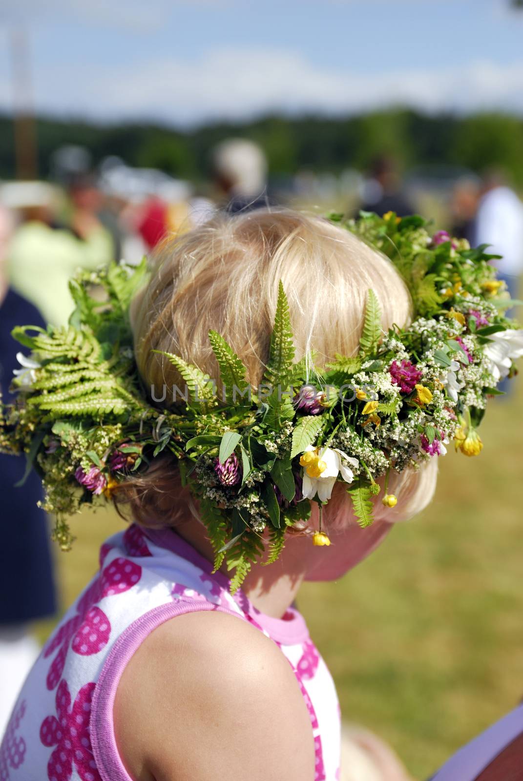 Midsommer (midsommar) flowers in young girls hair. Celebrating Swedish midsommar holiday.