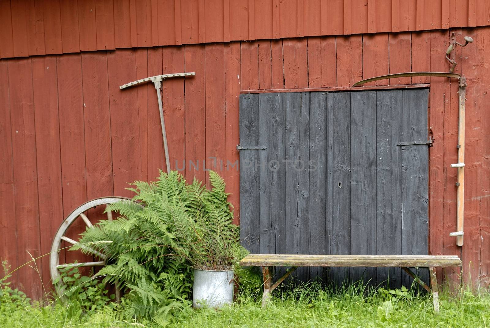 Old wheel on barn wall.