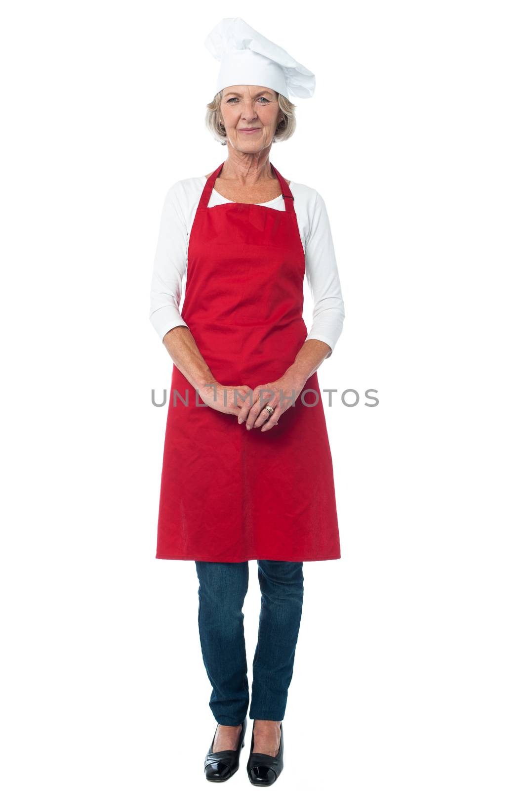 Full length of aged woman chef with hands clasped