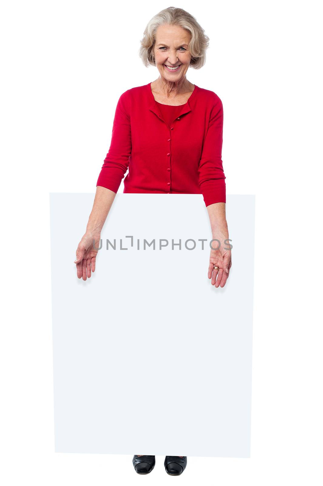 Aged woman standing behind blank billboard