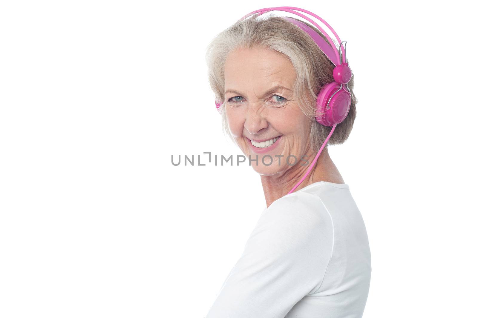Aged happy woman listening music on earphones