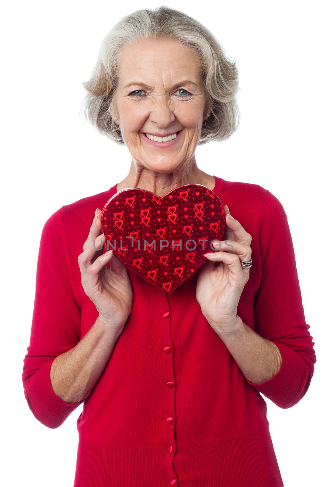 Mature woman showing heart shaped gift box