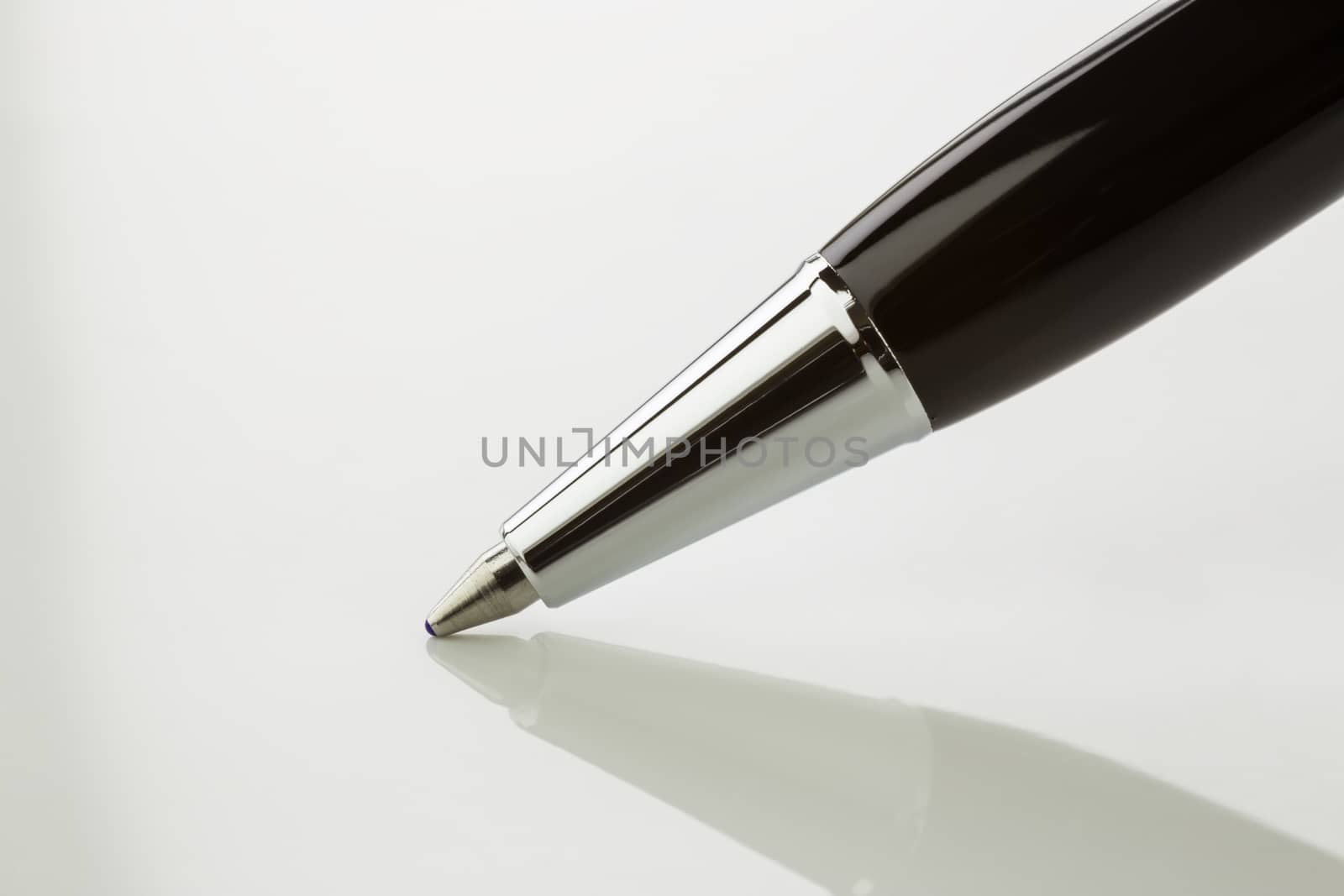 Close up ballpoint pen with blue ink color on  tip of ballpoint pen and shadow on white background, black and white tone image.