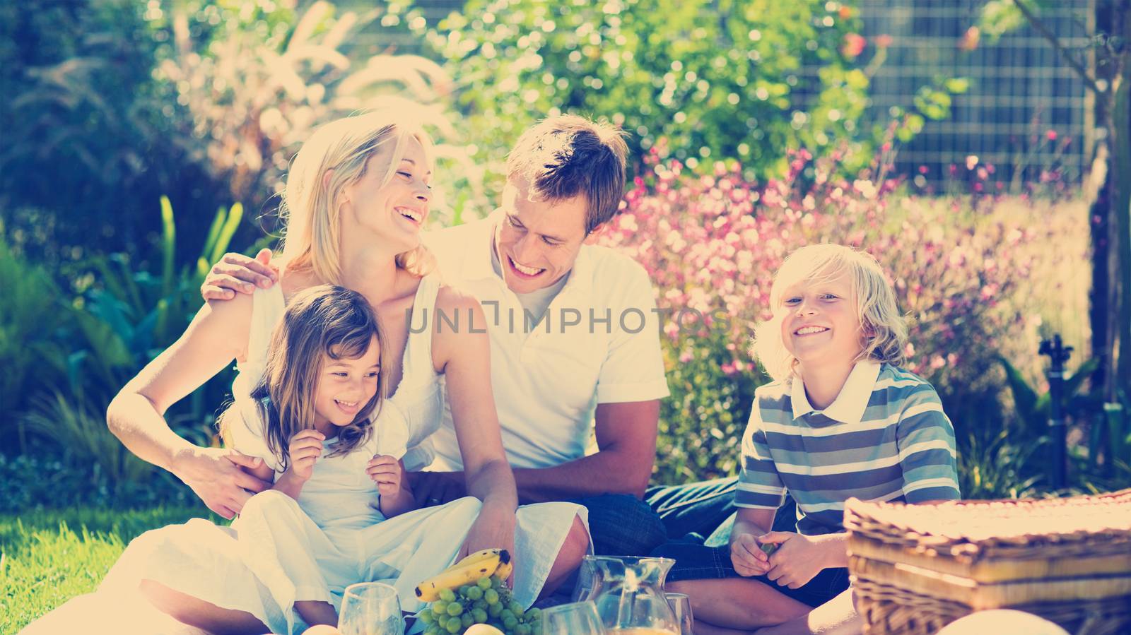 Happy family playing together in a picnic by Wavebreakmedia