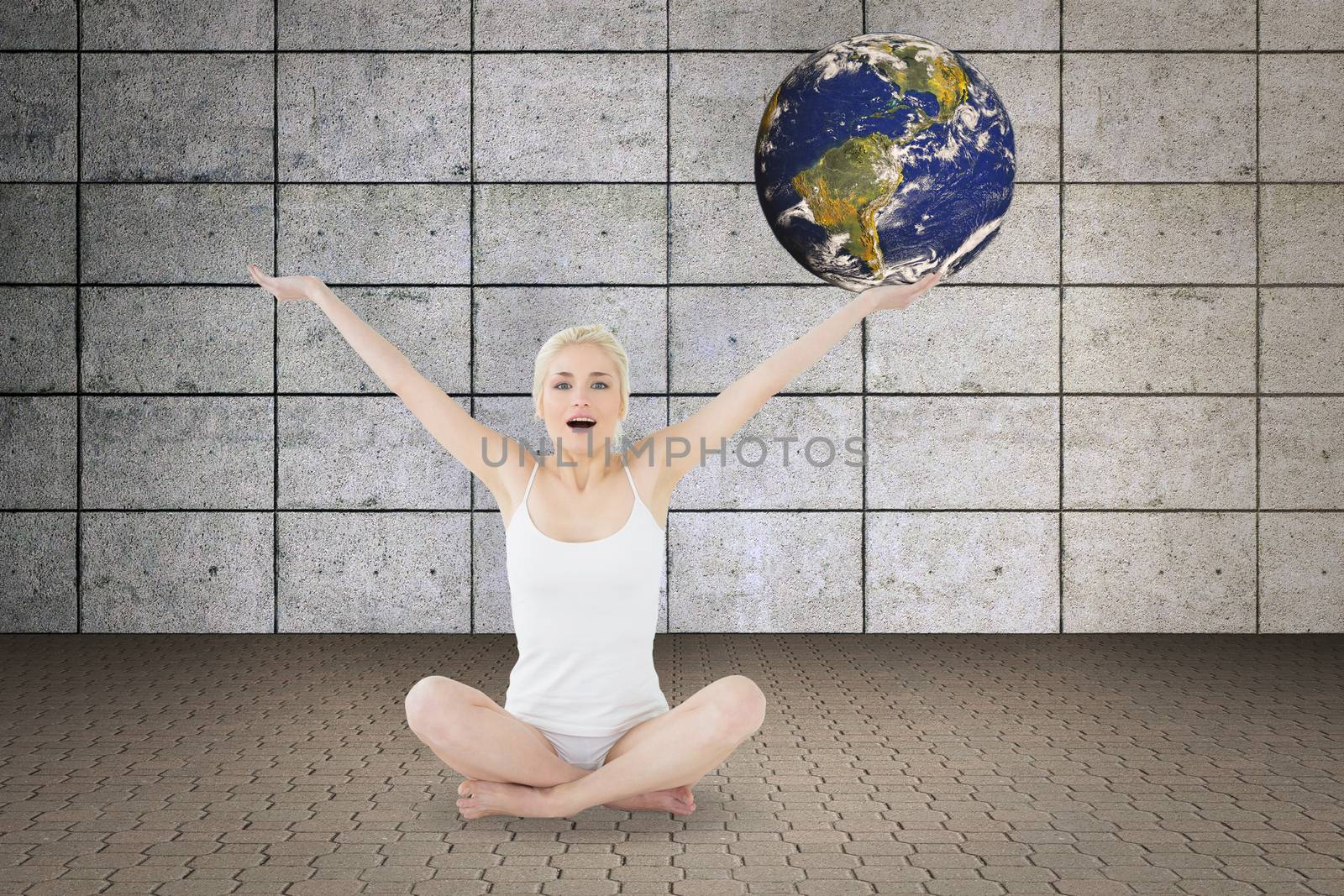 Toned young woman sitting with arms outstretched against grey room