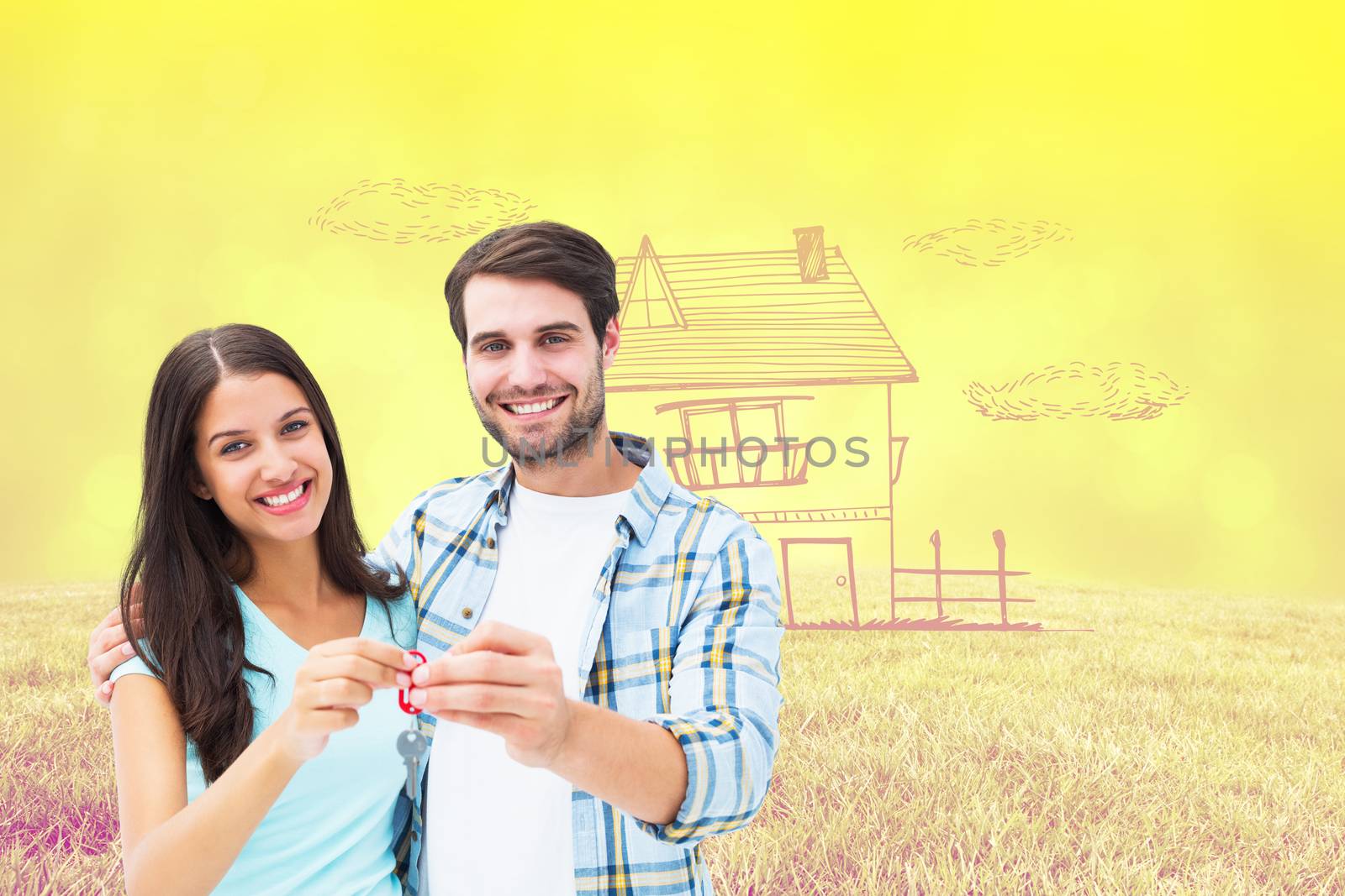 Happy young couple showing new house key against field against glowing lights