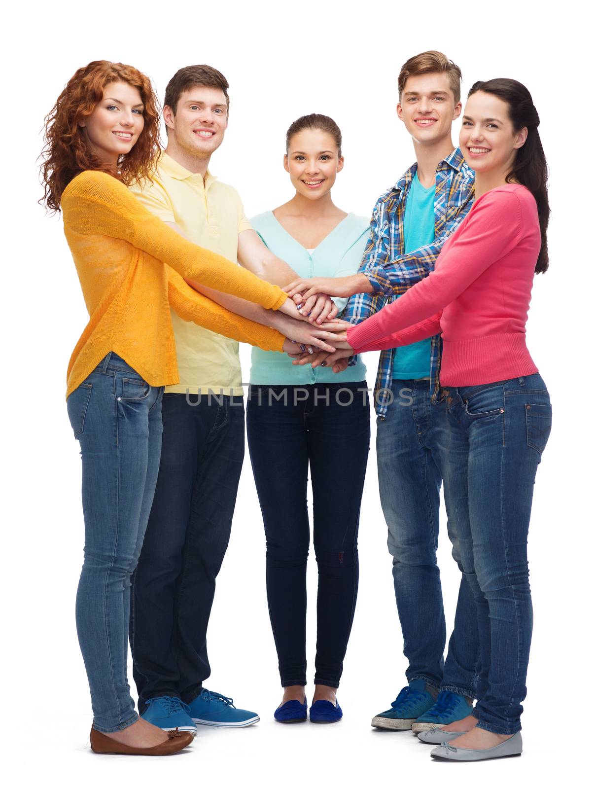 friendship, youth, gesture and people - group of smiling teenagers with hands on top of each other