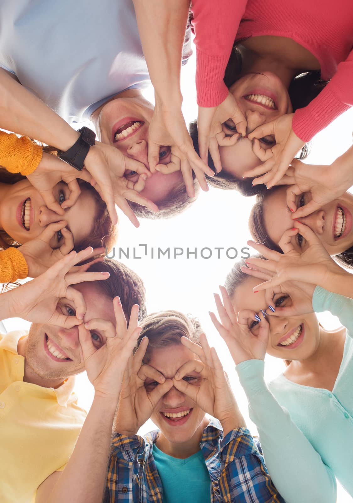 friendship, youth, gesture and people - group of smiling teenagers in circle having fun