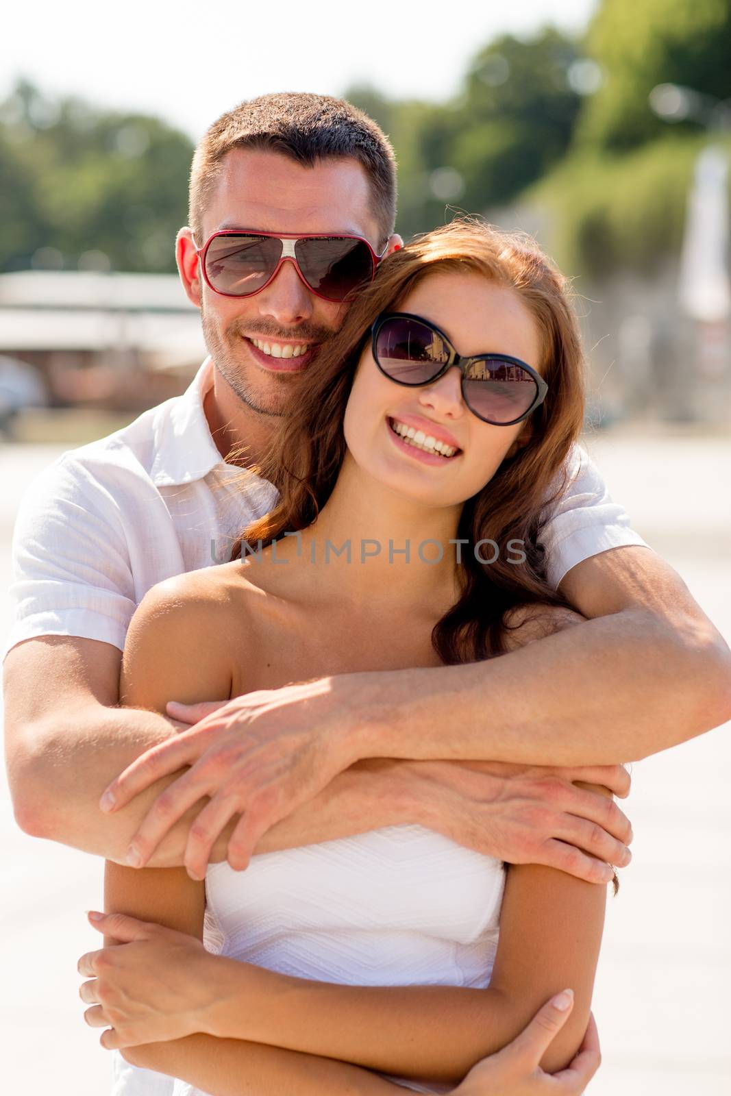 love, wedding, summer, dating and people concept - smiling couple wearing sunglasses hugging in park