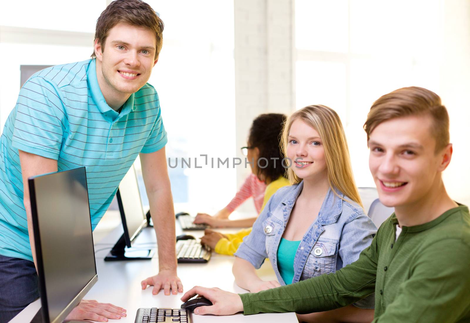 education, technology and school concept - group of smiling students in computer class