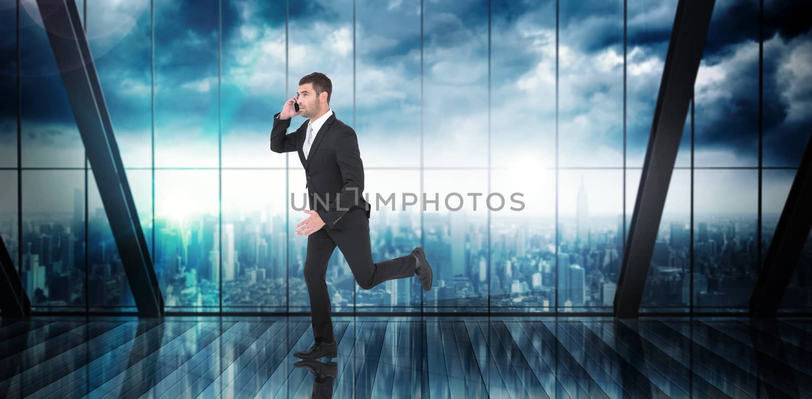 Businessman running on the phone  against room with large window looking on city