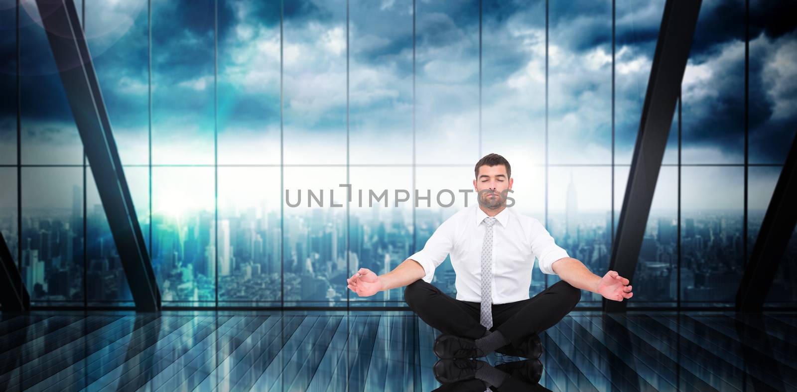 Businessman meditating in lotus pose against room with large window looking on city