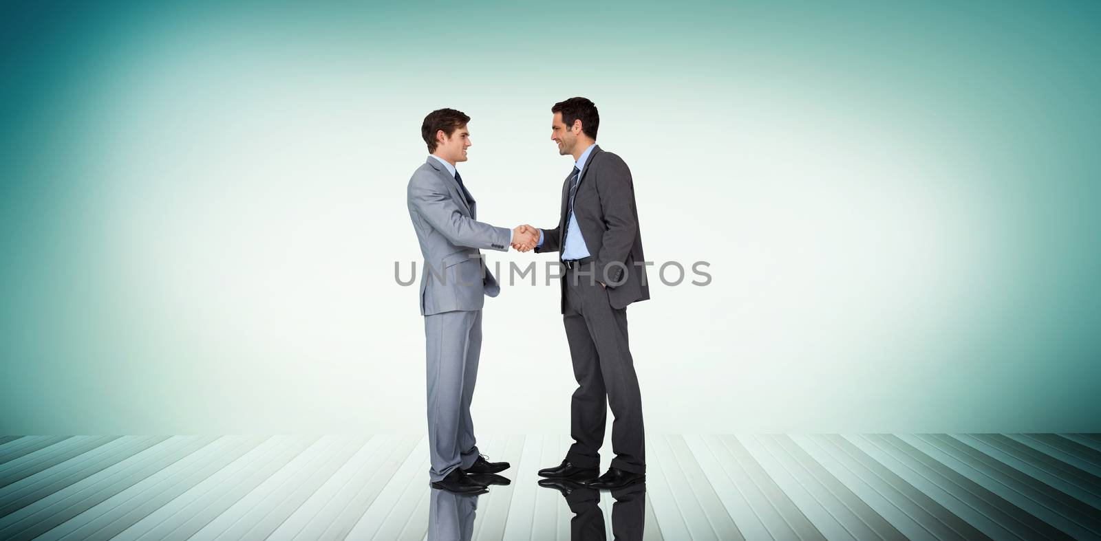 Businessmen shaking hands against blue vignette background