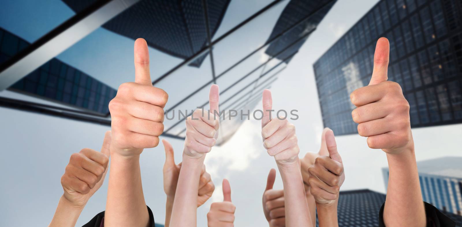 Hands showing thumbs up against skyscraper