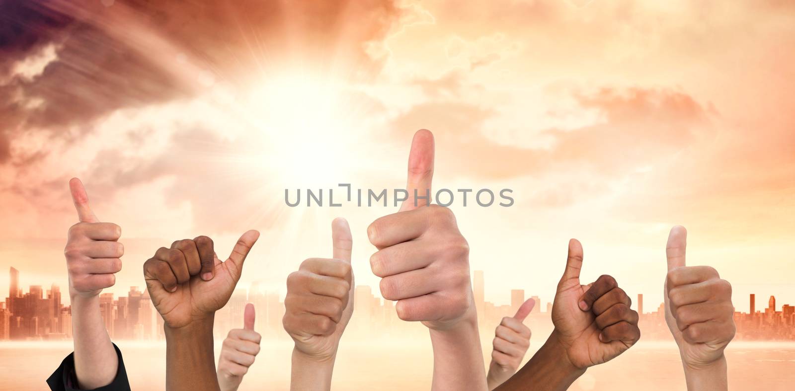 Hands showing thumbs up against sun shining over city