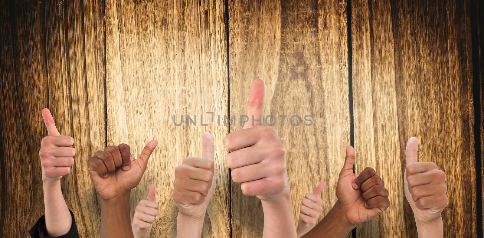 Hands showing thumbs up against wooden table