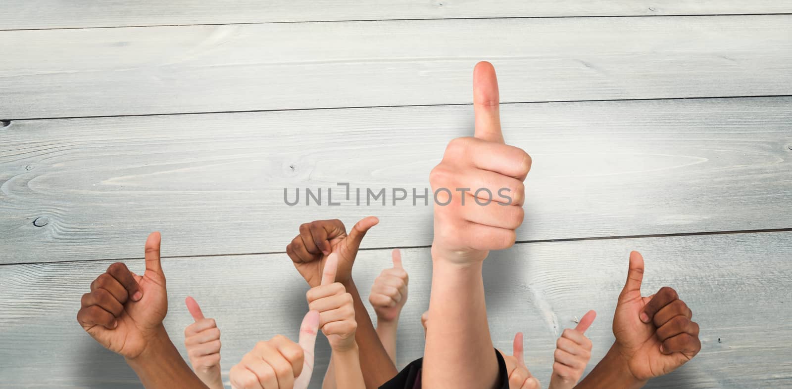 Hands showing thumbs up against bleached wooden planks background