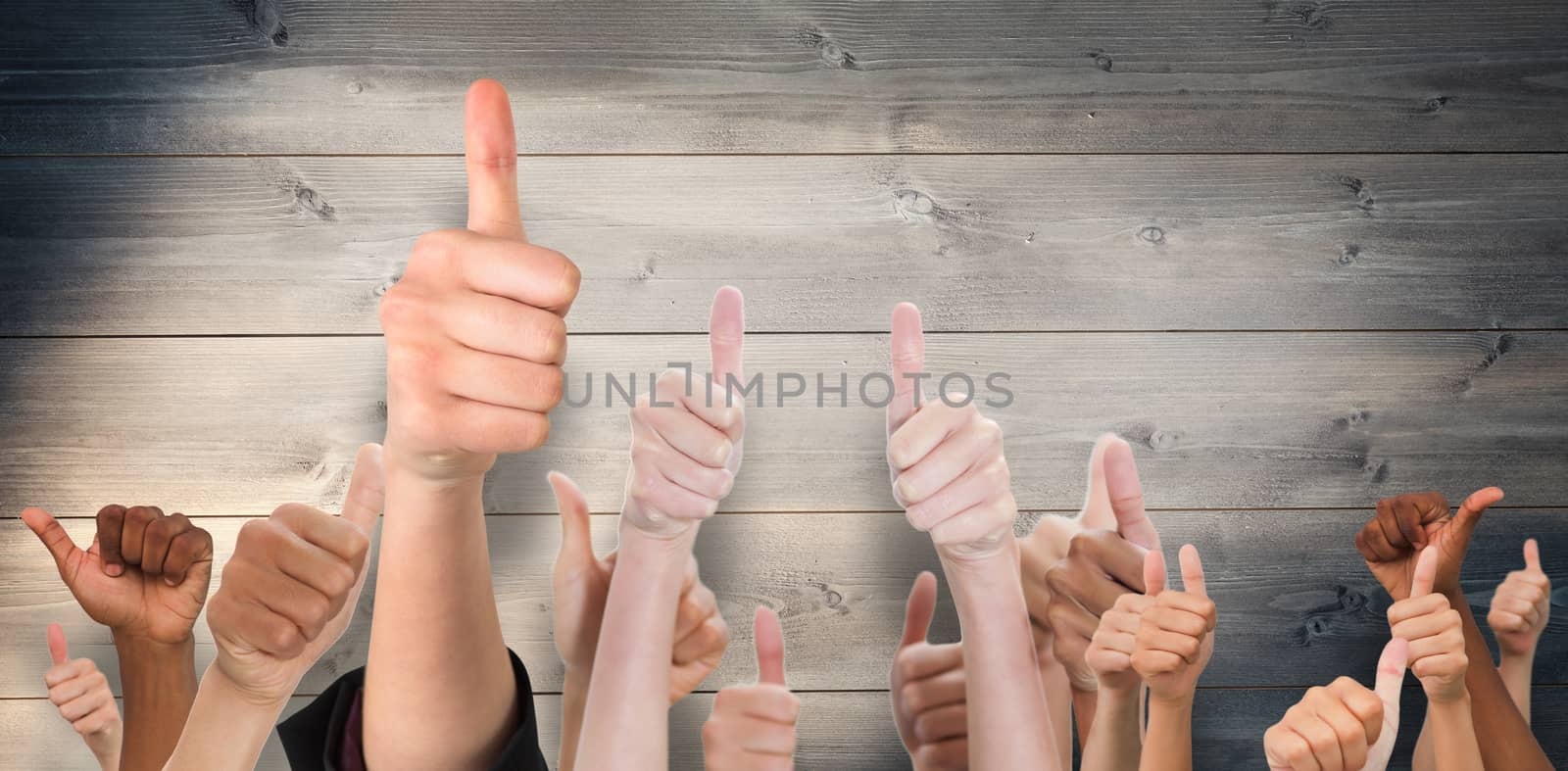 Hands showing thumbs up against bleached wooden planks background