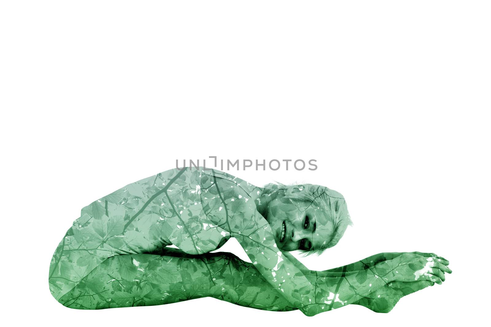 Toned woman doing the paschimottanasana pose against branches and leaves