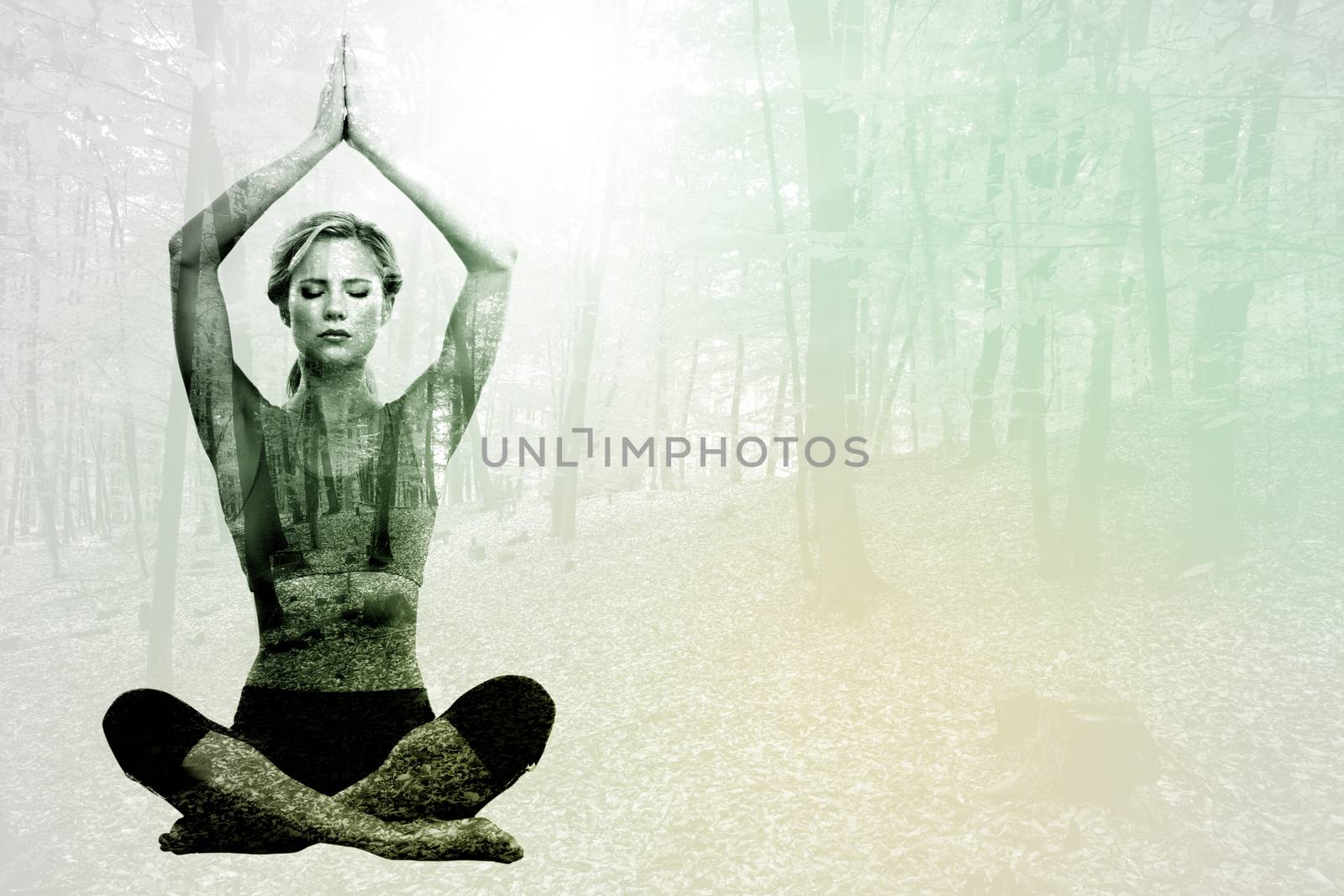 Calm blonde meditating in lotus pose with arms raised against autumnal forest