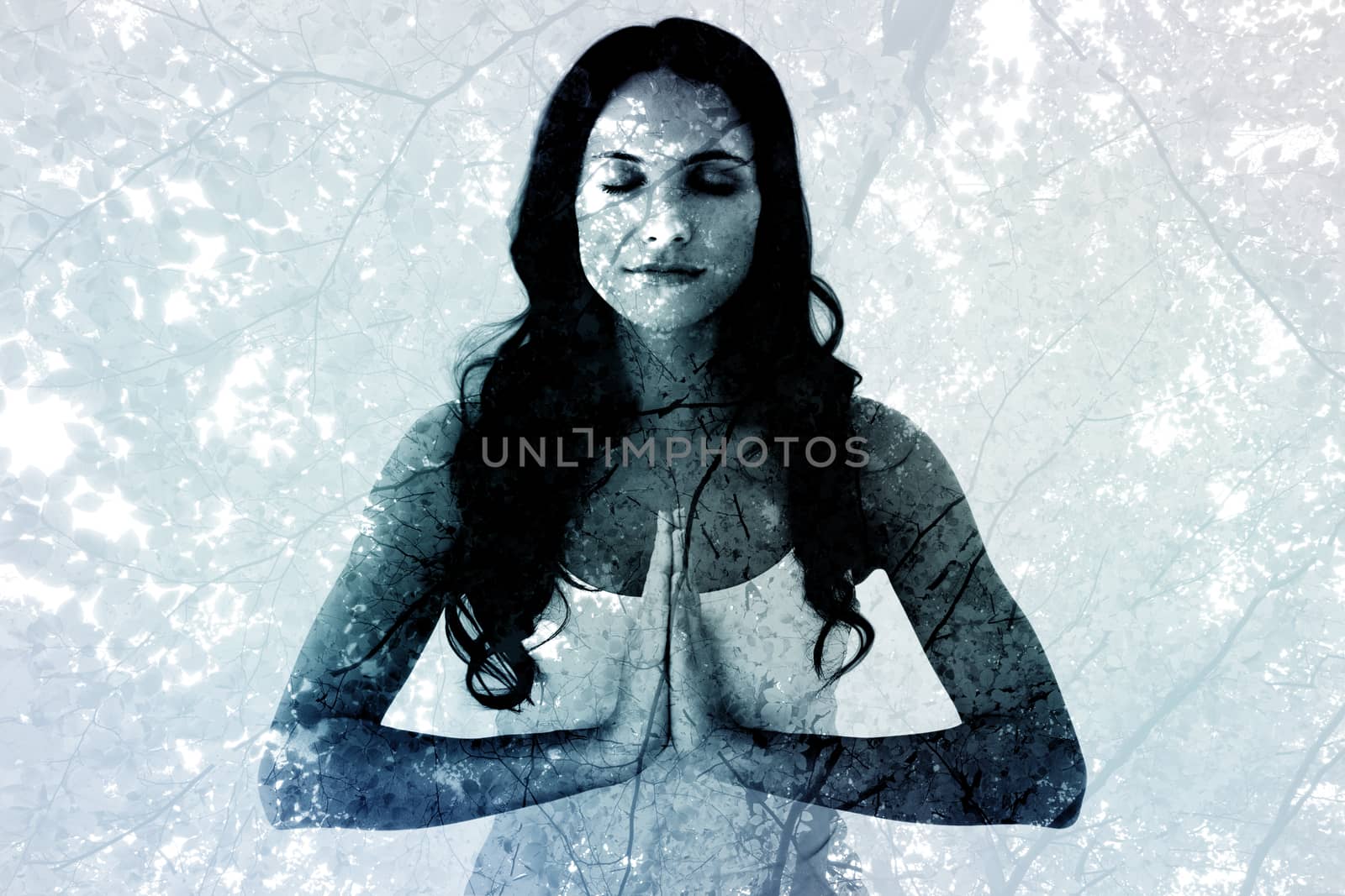 Pretty brunette doing yoga against branches and autumnal leaves