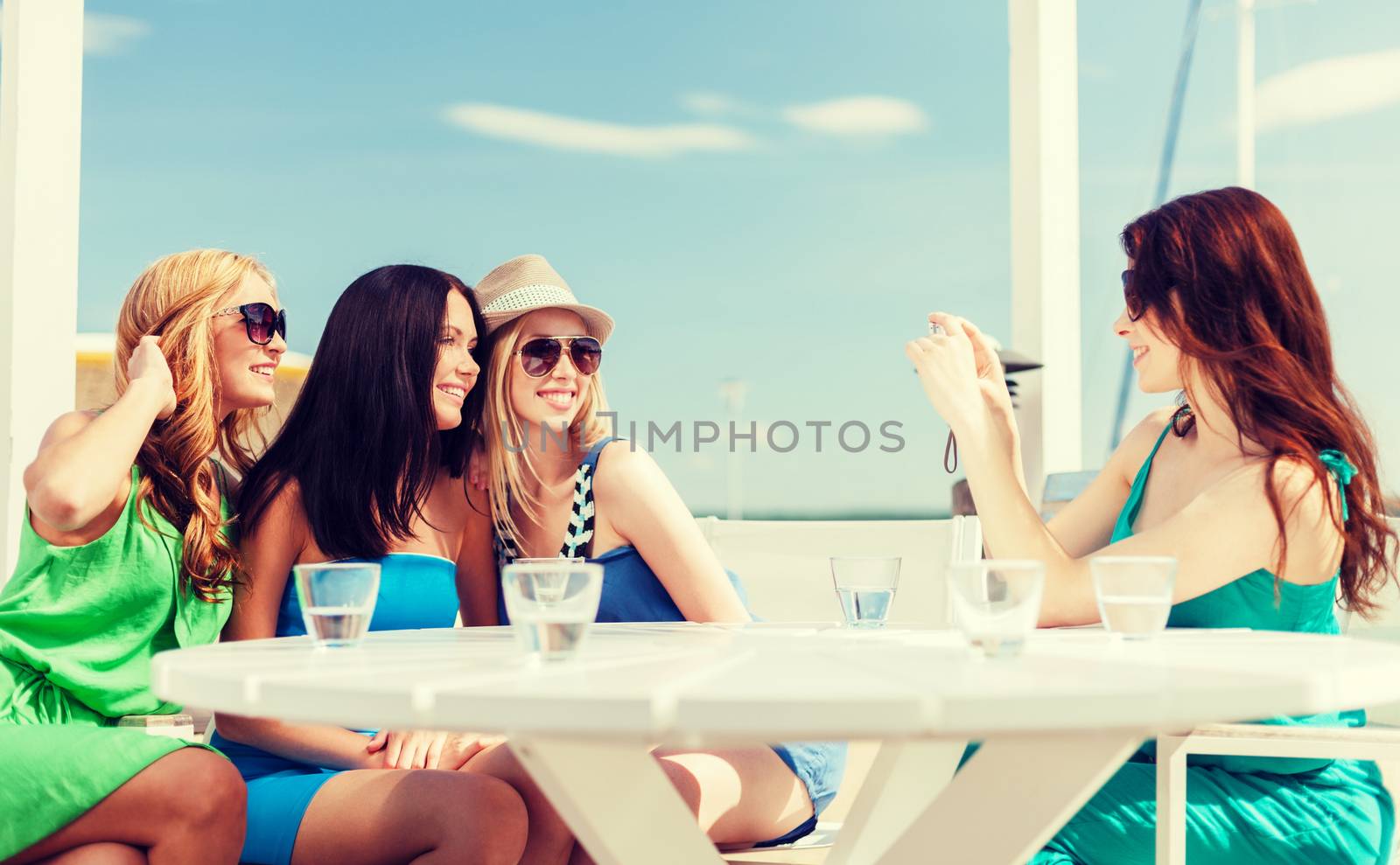 girls taking photo in cafe on the beach by dolgachov