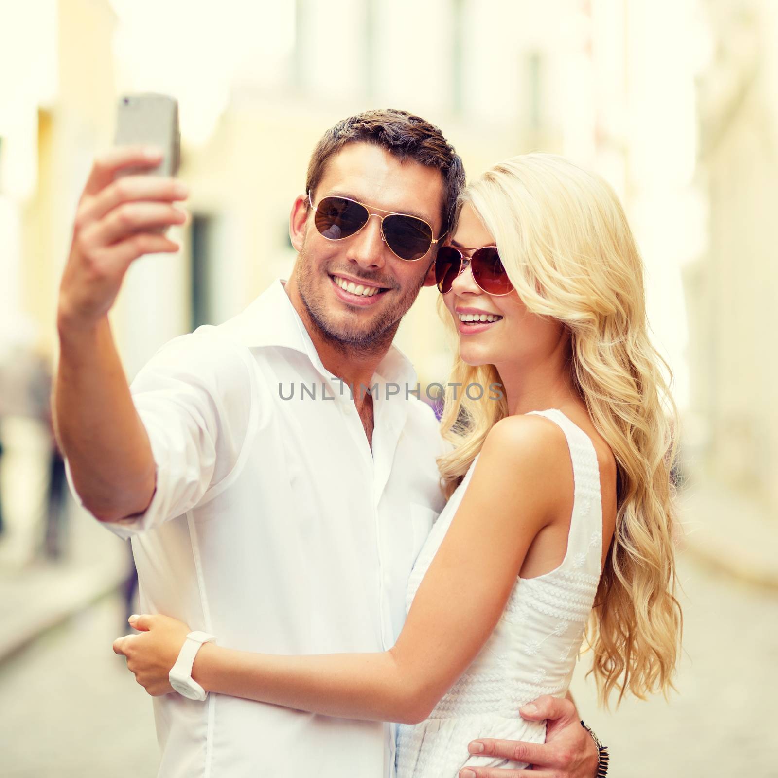 smiling couple taking selfie with smartphone by dolgachov