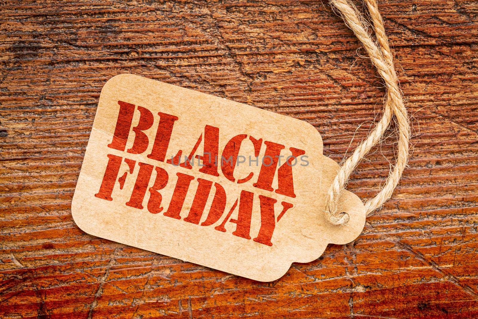Black Friday sign a paper price tag against rustic red painted barn wood