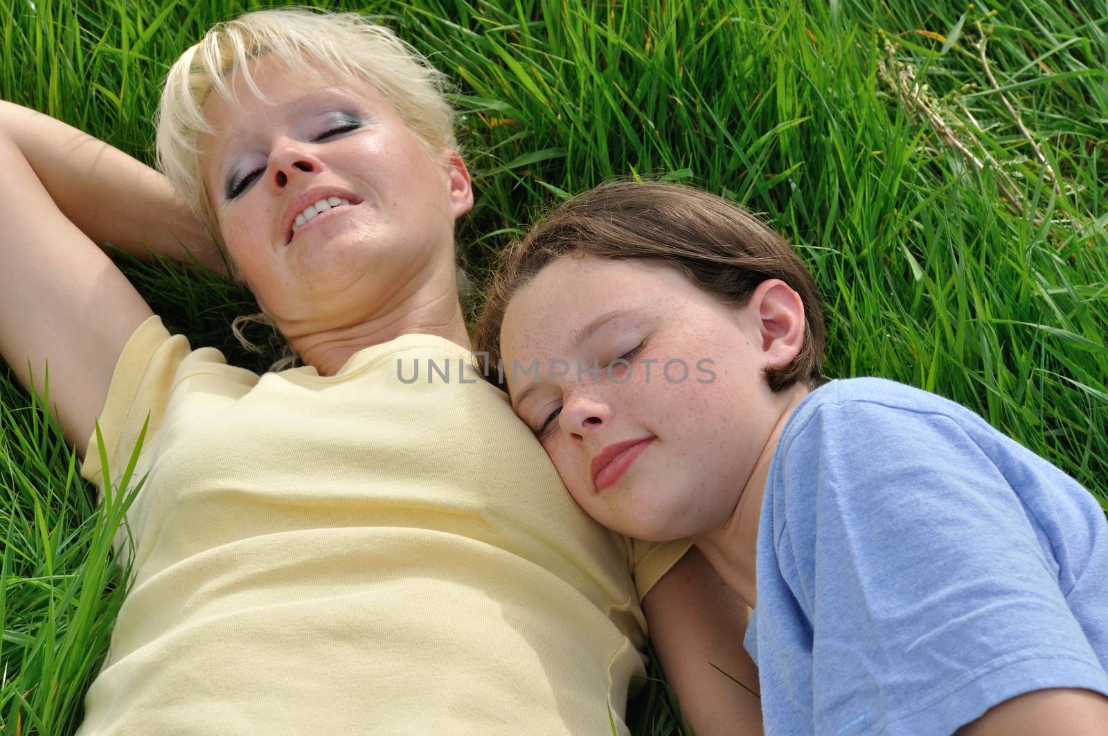 Mother and daughter making a nap on the grass