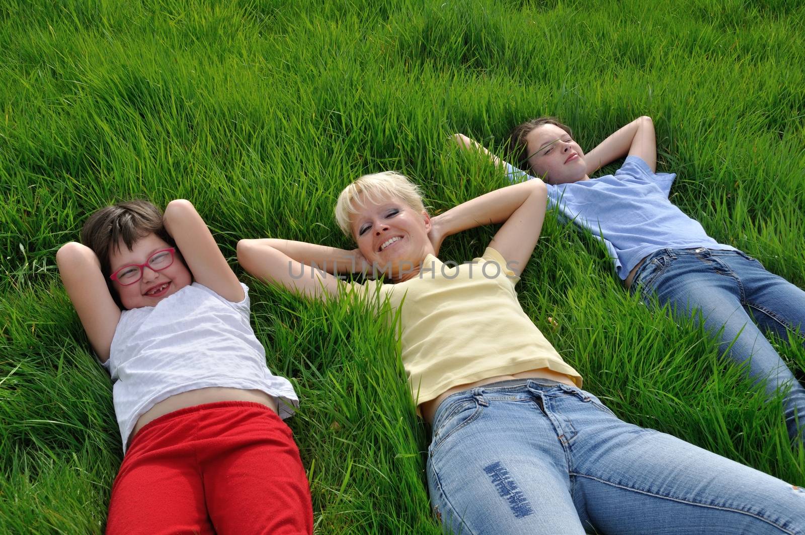 Mother and daughters making a nap on the grass