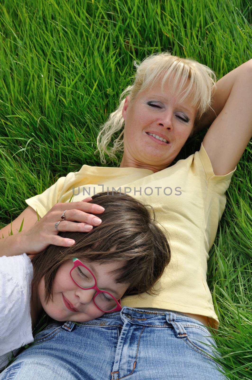 Mother and daughter making a nap on the grass