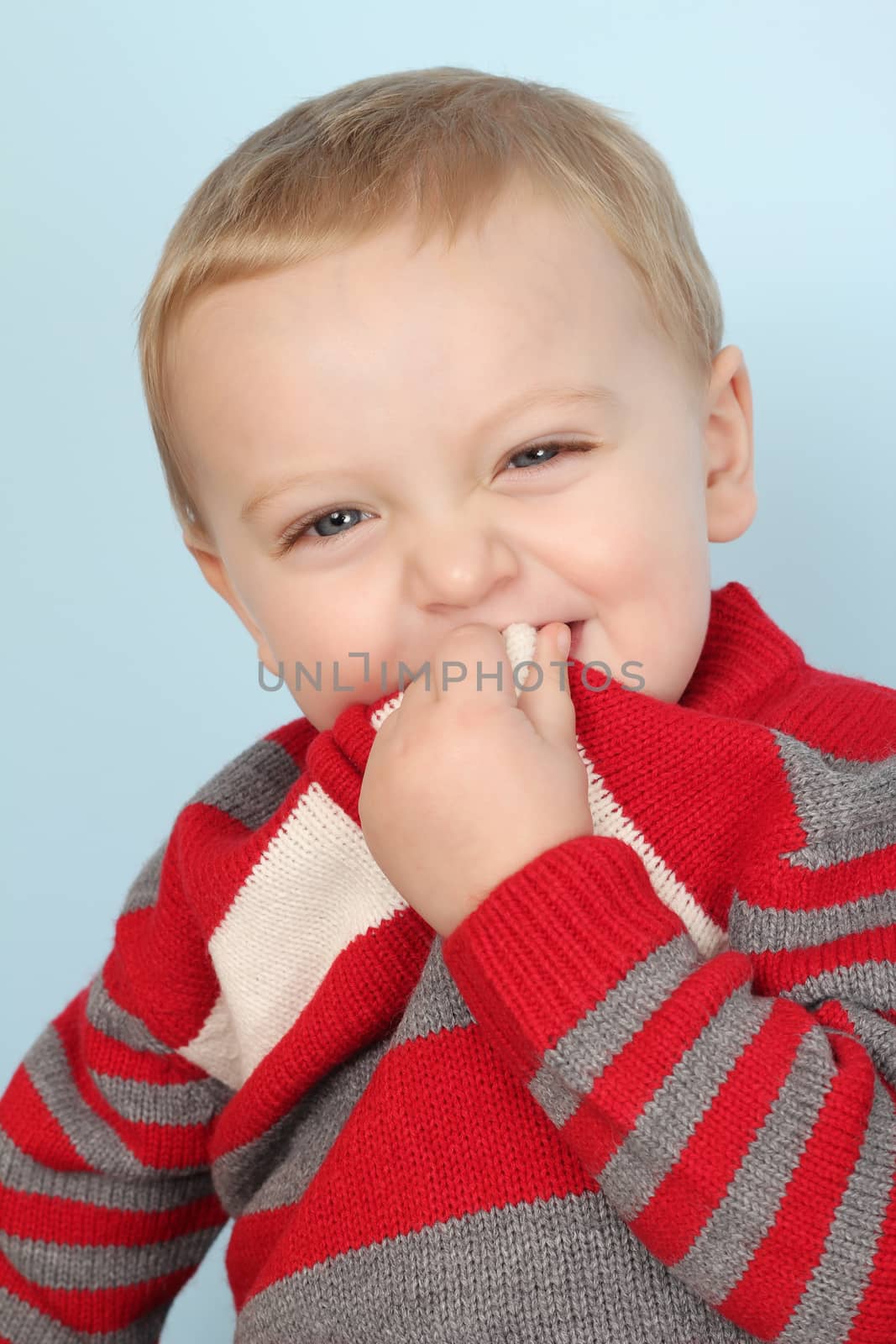 Blonde baby boy against a blue background