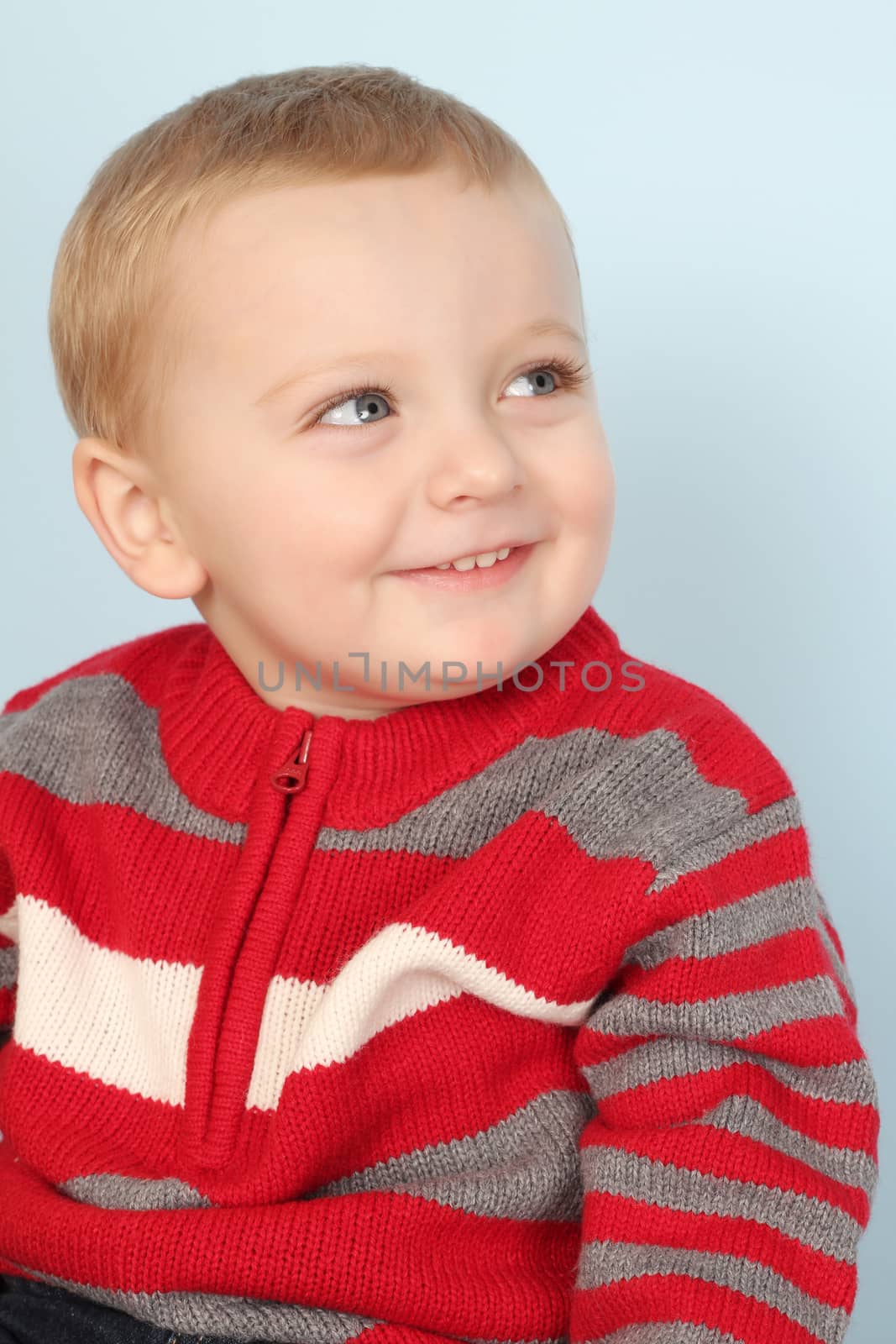 Blonde baby boy against a blue background