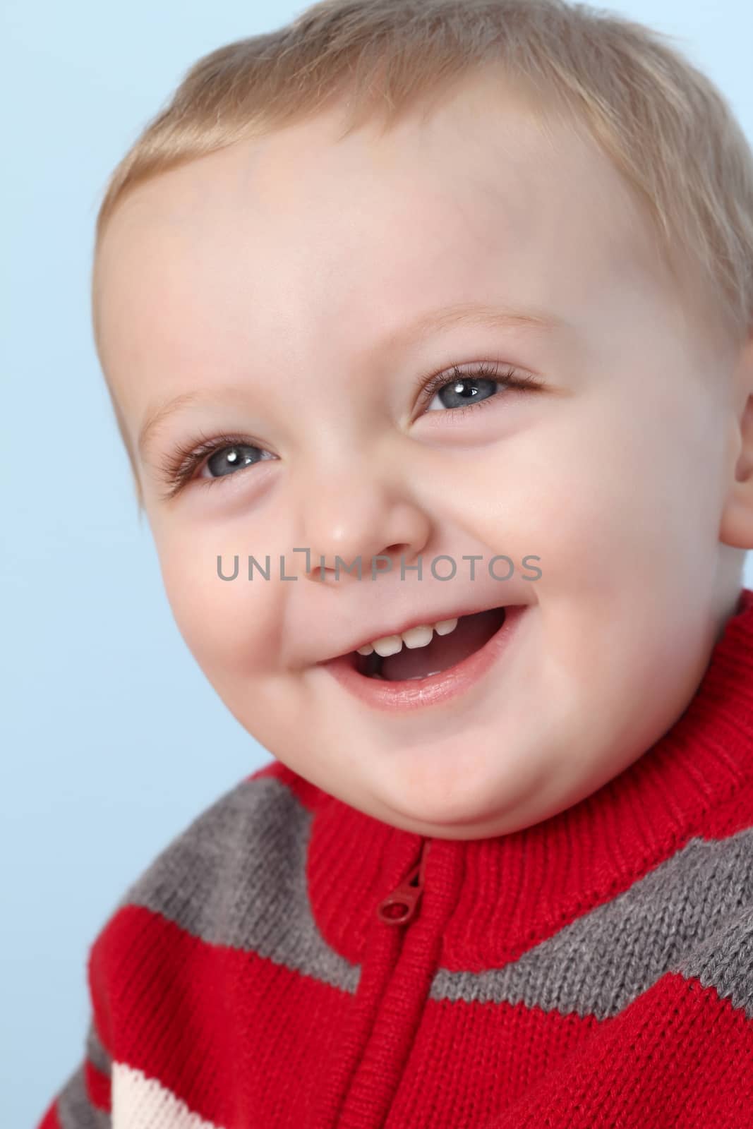 Blonde baby boy against a blue background